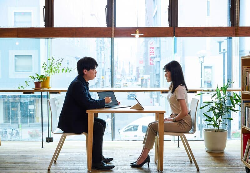 窓際の席で向かい合って話す二人